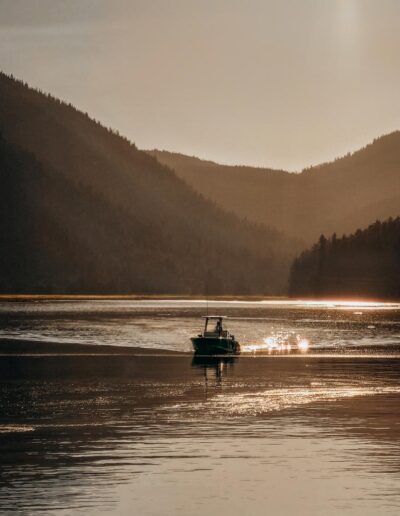 Small boat approaching during sunset. The light creates sparkles on the water surface.