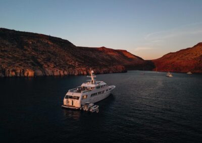 Drone footage of yacht and tenders during sunset